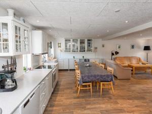 cocina y sala de estar con mesa y sofá en Two-Bedroom Holiday home in Løkken 6, en Løkken