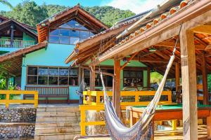a house with a hammock outside of it at Hotel da Inês in Visconde De Maua