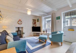 un soggiorno con divano, sedie e TV di 9 Teetotal Street a St Ives