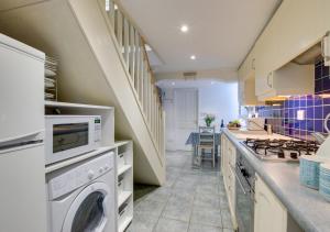 una cucina con lavatrice, asciugatrice e scala di 9 Teetotal Street a St Ives
