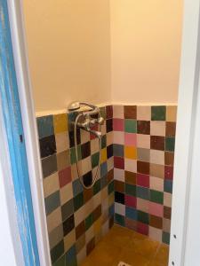 a bathroom with a shower with a colorful tile wall at Dar el pirata in Asilah