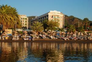 فندق باشا بيتش في مرماريس: مجموعة من الكراسي والمظلات على شاطئ قريب من الماء