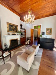 uma sala de estar com lareira e um lustre em Casa Verde Petrópolis em Petrópolis