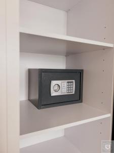 a shelf with a safe in a white closet at RentHouse Apartments Premium Living in Chişinău