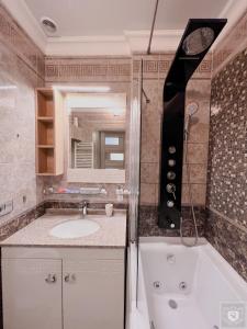 y baño con bañera, lavamanos y ducha. en RentHouse Apartments Premium Living en Chisináu