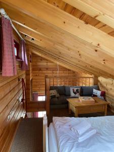 eine Blockhütte mit einem Bett und einem Sofa in der Unterkunft Blockhaus an der Skiwiese Braunlage in Braunlage