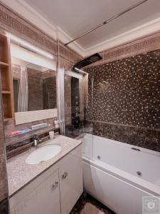 y baño con lavabo, bañera y espejo. en RentHouse Apartments Premium Living en Chisináu