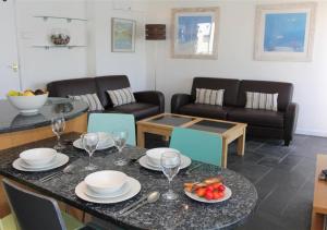a living room with a table with plates and wine glasses at 1 White Hart House The Wharf in St Ives