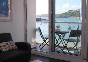 a room with a balcony with a table and chairs at 1 White Hart House The Wharf in St Ives