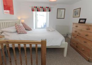 a bedroom with a bed with a window and a dresser at 1 White Hart House The Wharf in St Ives