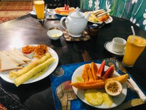 a table with plates of food and drinks on it at Serendipity Lake Artistic Bungalow by Heidis Home in Nuwara Eliya