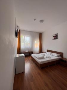 1 dormitorio con 1 cama grande y suelo de madera en Steffano Costinesti, en Costinesti