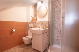 a bathroom with a sink and a toilet and a mirror at Sketches of Milna in Milna +26 photos
