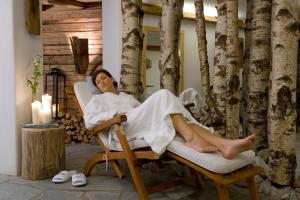 a woman laying in a chair in a spa at LANIG Hotel Resort&Spa - Wellness und Feinschmeckerhotel - family owned and managed in Oberjoch