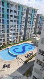 a swimming pool in front of some apartment buildings at Davao Vacation Hub near Sasa ferry terminal with netflix,Wifi, pool access in Davao City