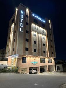 a hotel building with a sign on it at night at Taj Al Eiman Hotel in Al Madinah