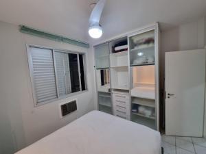 una camera da letto con un letto bianco e una finestra di Estúdio Beira Mar a Florianópolis