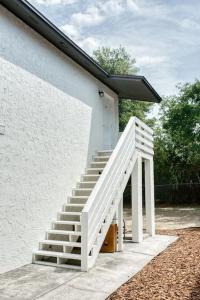 a white staircase next to a white building at Jay's Cozy Escape - A step from Busch Gardens in Tampa