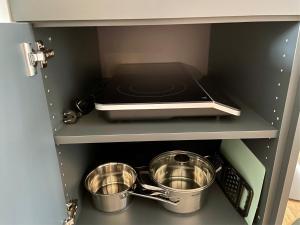 eine Küche mit zwei Töpfen und Pfannen auf einem Regal in der Unterkunft MK Appartements in Bad Abbach