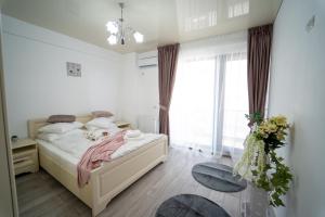 1 dormitorio con cama y ventana grande en Almar Luxury Residence - Renting Apartments & Free Pool, en Mamaia Nord – Năvodari