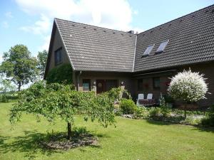 una casa con un árbol delante en Timmerloher Weg, Ferienwohnung, en Schneverdingen