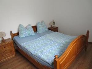 Un dormitorio con una cama con sábanas azules y almohadas azules. en Timmerloher Weg, Ferienwohnung, en Schneverdingen