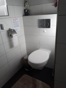 Un baño con un inodoro blanco en una cabina. en Timmerloher Weg, Ferienwohnung, en Schneverdingen 9 fotos más