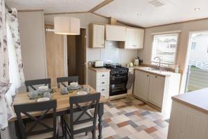 a kitchen with a table and chairs in a kitchen at Mallard Lake in South Cerney