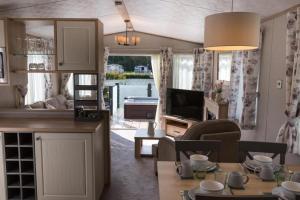 cocina y sala de estar con sofá y TV en Mallard Lake en South Cerney