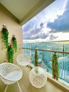 uma varanda com mesas e cadeiras e uma grande janela em Sala Hotel - The Sóng Vũng Tàu em Vung Tau
