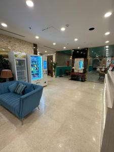 فندق تاج الإيمان في المدينة المنورة: غرفة معيشة مع أريكة زرقاء في متجر