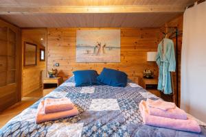 um quarto com uma cama com almofadas azuis e cor-de-rosa em Eco Chalet , Grande Terrasse em Sospel