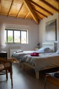 two beds in a bedroom with a wooden ceiling at The Pool House in Longos
