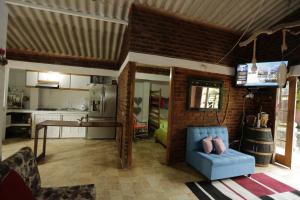 sala de estar con sofá azul y cocina en Casa Finca Sancami 1, en Guamal