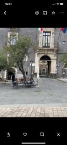 una foto di un edificio con cortile e panchine di PAPALI loft a Catania