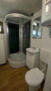 a bathroom with a shower and a toilet and a sink at Lux Camping Costinesti in Costinesti