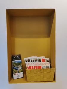 a box with books and magazines on a shelf at Comfortable apartment close to the center and sea in Gdańsk