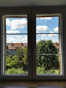 two windows in a room with views of a building at Comfortable apartment close to the center and sea in Gdańsk