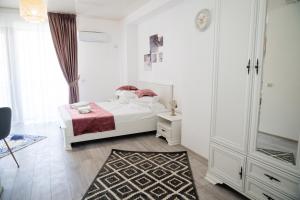 Habitación blanca con cama y alfombra en Almar Luxury Residence - Renting Apartments & Free Pool, en Mamaia Nord – Năvodari