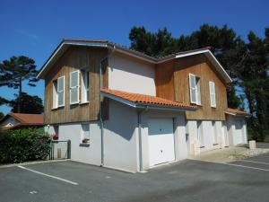 a house with a garage with a lot at Marensines - Capbreton jolie villa mitoyenne sur grand jardinet et terrasse en bois in Capbreton