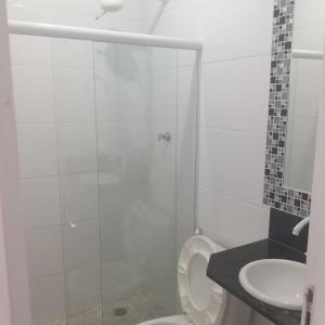 a bathroom with a shower and a toilet and a sink at Pousada Azul Atlântica in Guarapari