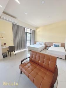 um quarto de hotel com duas camas e um sofá em 溫怡鹿鹿 em Lukang