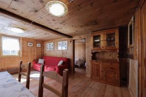 a living room with a red couch in a tiny house at La WalserHus in Formazza