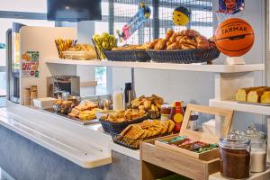 a bakery with bread and baskets of food on shelves at ibis budget Paris Porte d'Aubervilliers in Aubervilliers