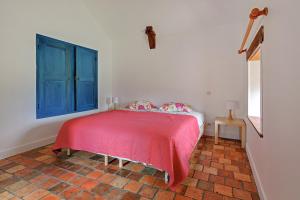 a bedroom with a red bed and a blue window at Le Moulin neuf in Alexain