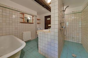 a bathroom with a bath tub and a sink at Le Moulin neuf in Alexain