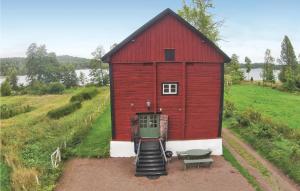 a red barn on a hill with a bench at Stunning Home In Gränna With Lake View in Gränna