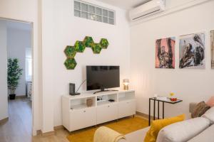 een witte woonkamer met een flatscreen-tv bij Cozy & Bright Lisbon-O campo na cidade in Lissabon