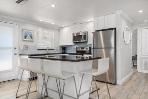 uma cozinha com armários brancos e um frigorífico de aço inoxidável em Island House Beach Resort 19 em Point O'Rocks