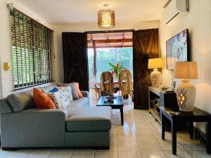 een woonkamer met een bank en een tafel bij La Mona Beach House in Jacó